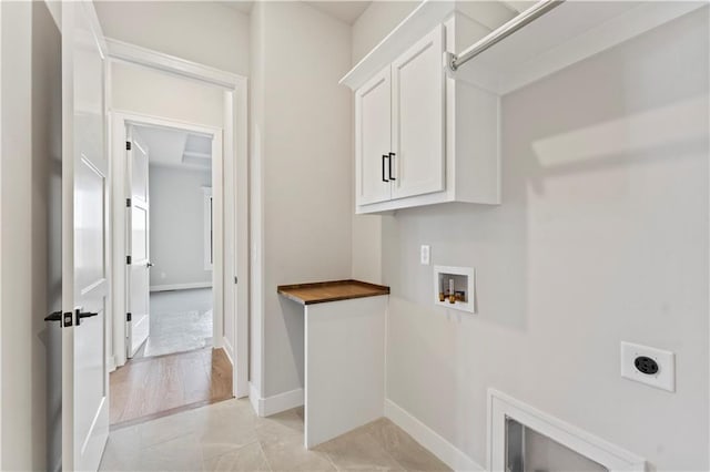 washroom with hookup for an electric dryer, washer hookup, light wood-type flooring, and cabinets