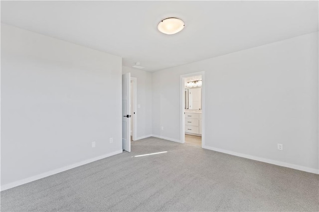 unfurnished bedroom featuring light carpet and ensuite bath