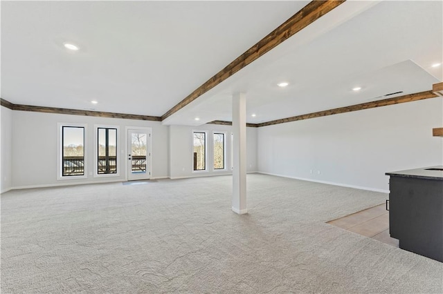 basement with a wealth of natural light and light colored carpet