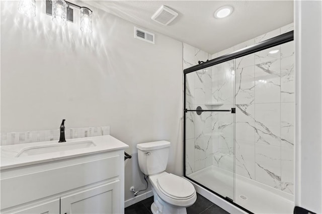 bathroom featuring tile patterned flooring, vanity, toilet, and a shower with shower door