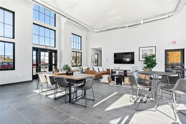 dining space with plenty of natural light and a towering ceiling