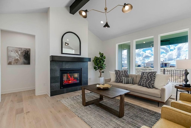 living room with light hardwood / wood-style flooring, a fireplace, high vaulted ceiling, and beamed ceiling