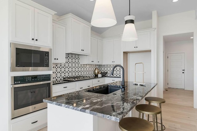 kitchen with white cabinetry, sink, a center island with sink, and appliances with stainless steel finishes