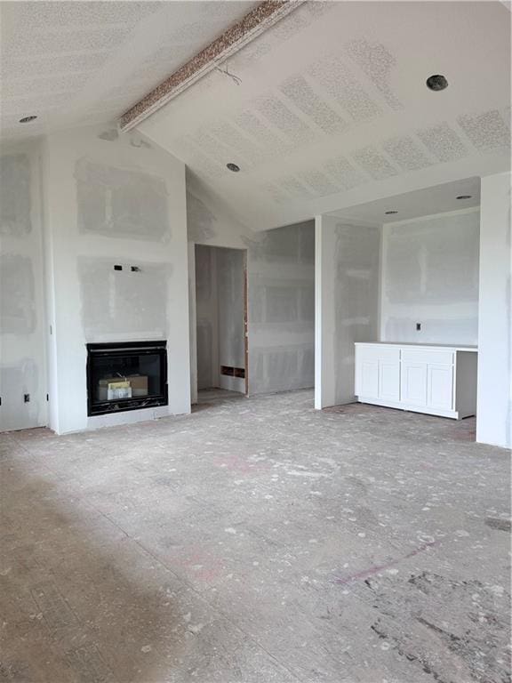 unfurnished living room featuring lofted ceiling with beams