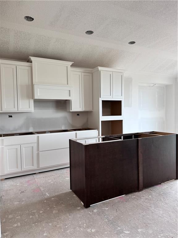 kitchen featuring white cabinetry and a textured ceiling