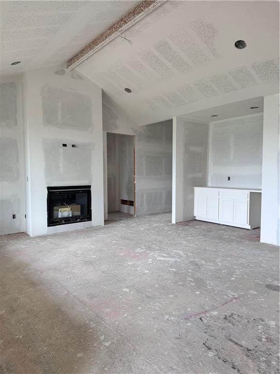 unfurnished living room featuring vaulted ceiling