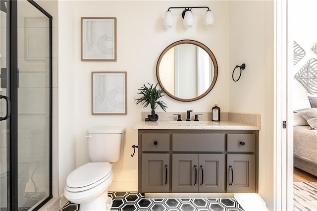 bathroom with vanity, toilet, and a shower with door