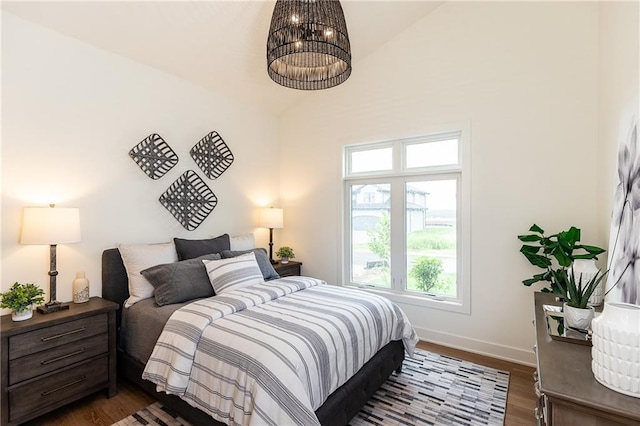 bedroom with dark hardwood / wood-style flooring and lofted ceiling