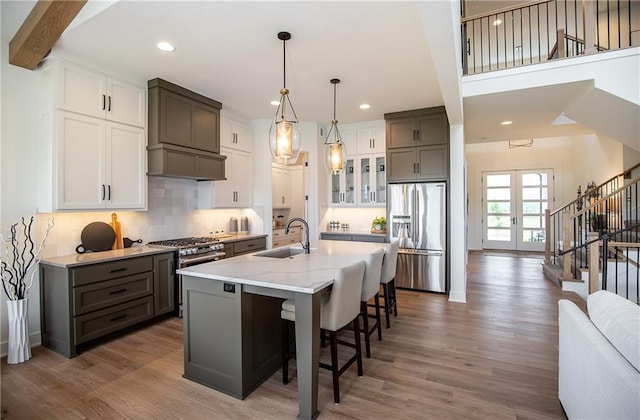 kitchen featuring french doors, sink, a center island with sink, white cabinets, and appliances with stainless steel finishes