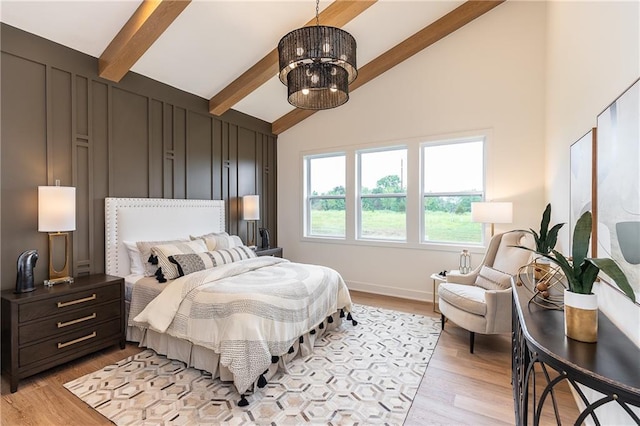 bedroom featuring light hardwood / wood-style flooring, beamed ceiling, a chandelier, and high vaulted ceiling