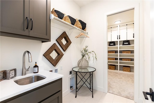 kitchen featuring light tile patterned floors, gray cabinets, and sink