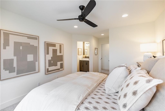 carpeted bedroom with ensuite bath and ceiling fan