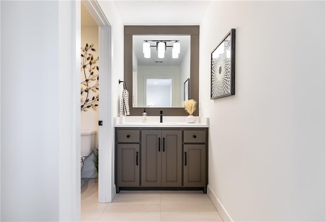 bathroom featuring tile patterned flooring, vanity, and toilet