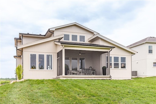 back of property featuring central air condition unit, a sunroom, a yard, and ceiling fan