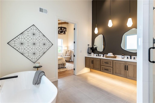 bathroom with a bathing tub, tile patterned flooring, and vanity