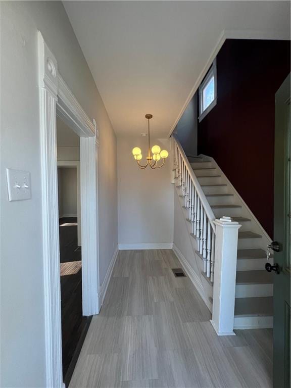 foyer entrance with an inviting chandelier and hardwood / wood-style flooring