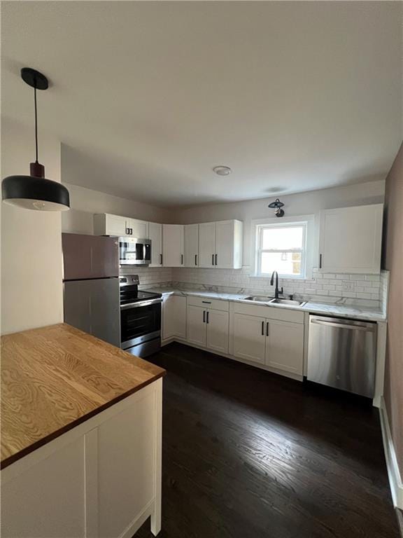 kitchen featuring dark hardwood / wood-style flooring, stainless steel appliances, backsplash, white cabinets, and sink