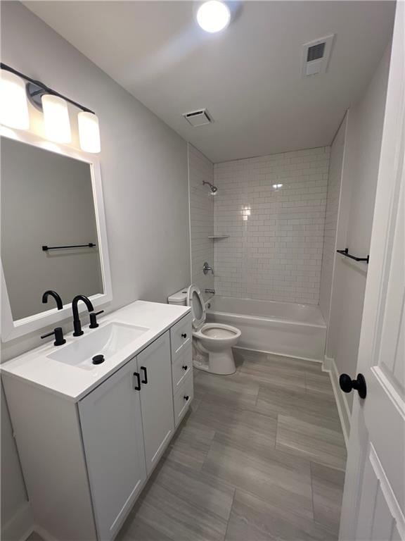 full bathroom featuring tile floors, tiled shower / bath, toilet, and vanity