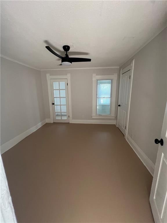 empty room with ceiling fan and crown molding