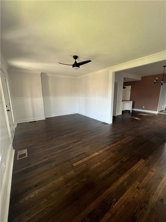 empty room featuring dark hardwood / wood-style floors, ceiling fan, and ornamental molding