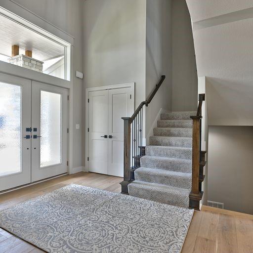 foyer with high vaulted ceiling, light wood-type flooring, and french doors