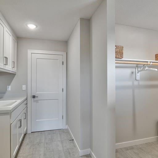 clothes washing area with sink and light tile floors