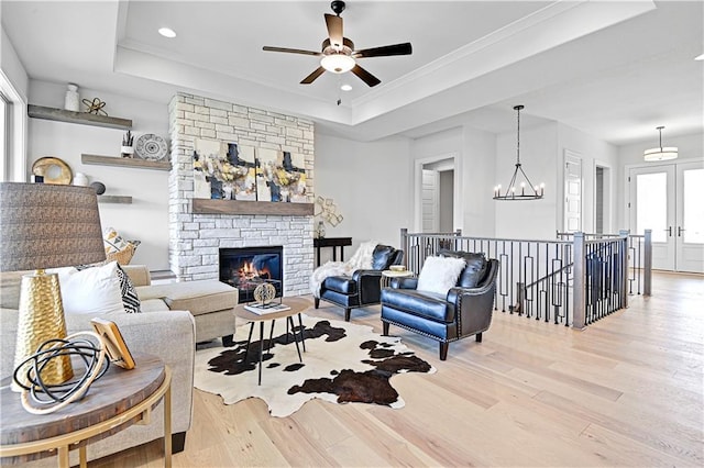 13028 S Constance St, Olathe, KS 66062 - living area featuring a raised ceiling, light wood finished floors, ceiling fan, recessed lighting, and a stone fireplace