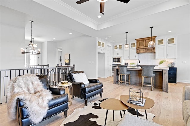 13028 S Constance St, Olathe, KS 66062 - living area featuring light wood finished floors, recessed lighting, a ceiling fan, crown molding, and a tray ceiling
