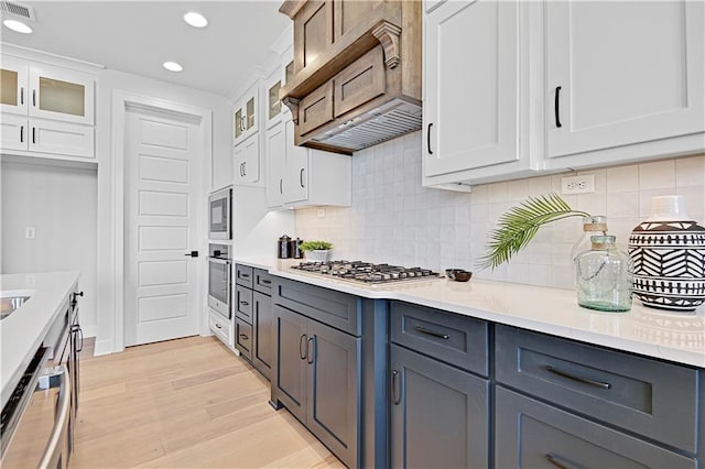 13028 S Constance St, Olathe, KS 66062 - kitchen with stainless steel appliances, white cabinets, light countertops, recessed lighting, and glass insert cabinets
