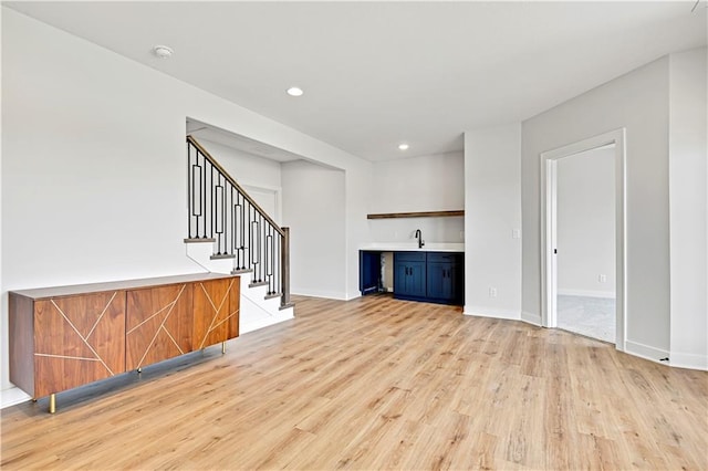 13028 S Constance St, Olathe, KS 66062 - unfurnished living room with light wood-type flooring, stairs, and recessed lighting