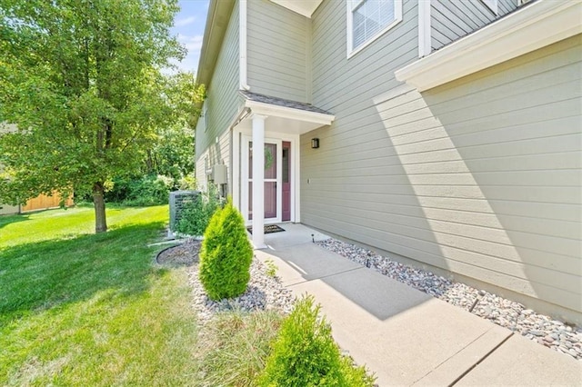 view of exterior entry featuring a lawn