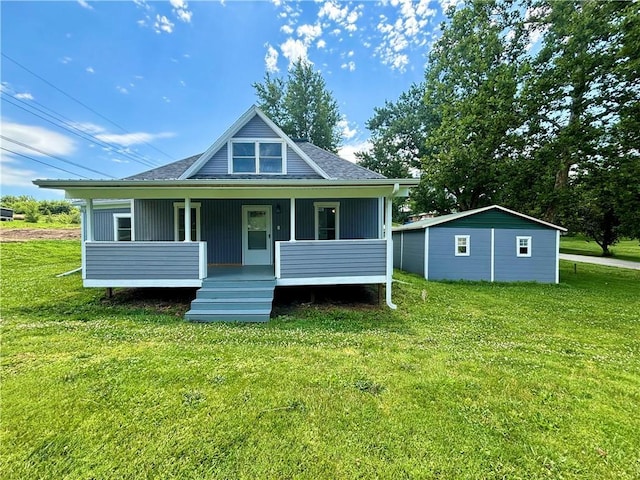 rear view of house with a porch, a yard, and an outdoor structure