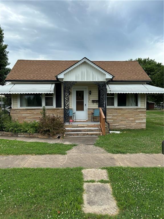 303 N Cayuga St, Frontenac, KS 66763 - bungalow-style house with stone siding, a front lawn, and a shingled roof