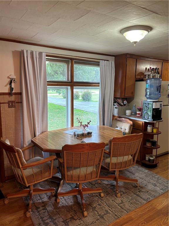 303 N Cayuga St, Frontenac, KS 66763 - dining area featuring light wood-style flooring and crown molding