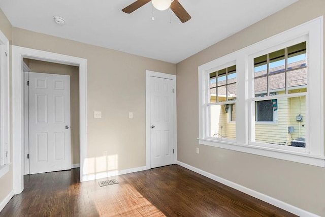 unfurnished bedroom featuring ceiling fan and dark hardwood / wood-style floors