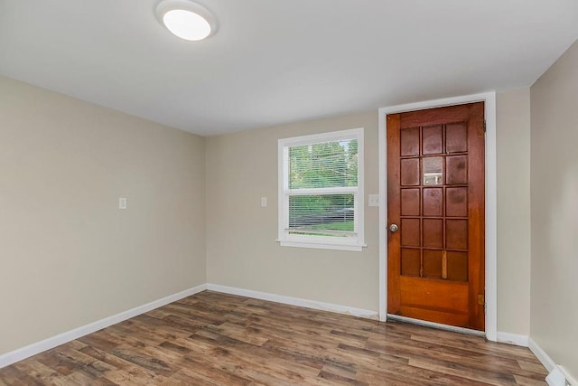 foyer entrance featuring a baseboard radiator and dark wood-type flooring