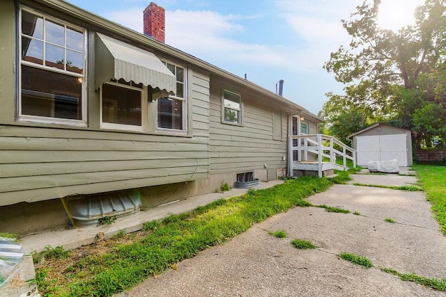 view of property exterior with a storage unit