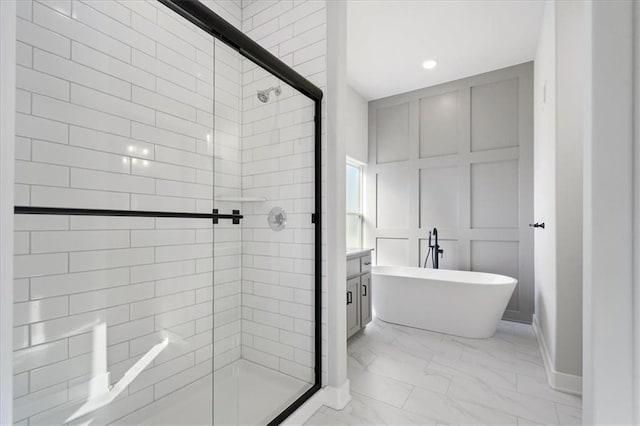 bathroom with marble finish floor, a freestanding tub, a shower stall, and a decorative wall