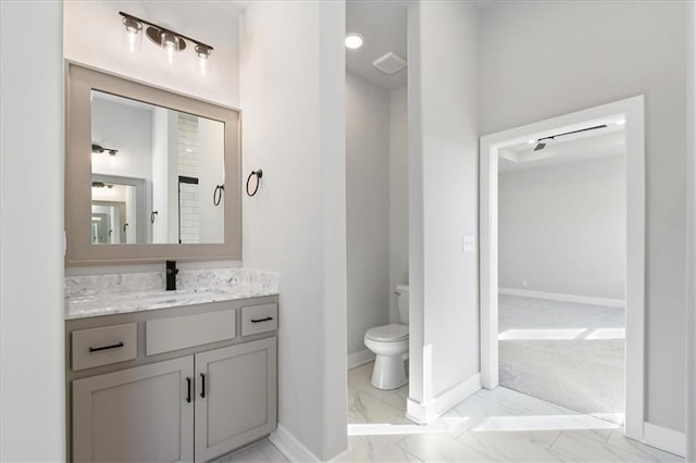 bathroom featuring toilet, visible vents, vanity, baseboards, and marble finish floor