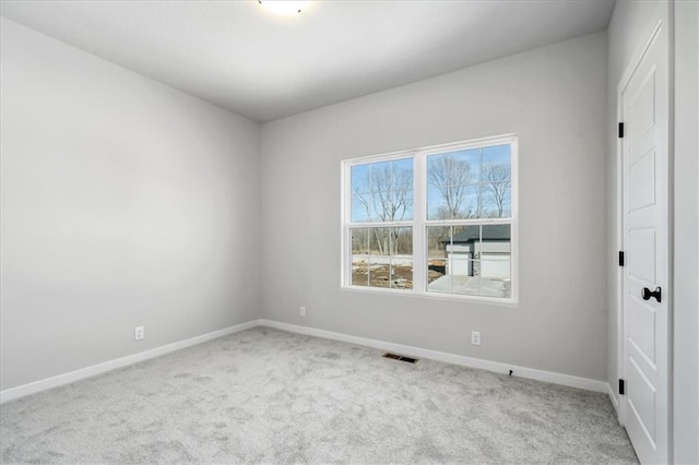 unfurnished room with carpet floors, visible vents, and baseboards