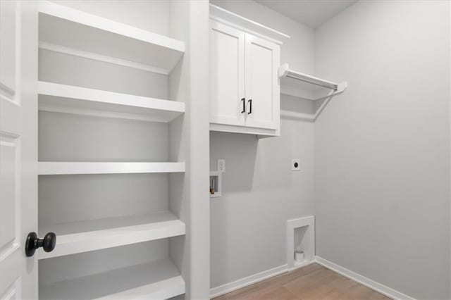 laundry area with cabinet space, baseboards, wood finished floors, washer hookup, and electric dryer hookup