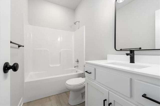 full bath featuring wood finished floors, shower / bathing tub combination, vanity, and toilet