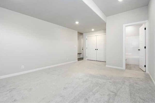 unfurnished bedroom featuring recessed lighting, a closet, carpet flooring, connected bathroom, and baseboards