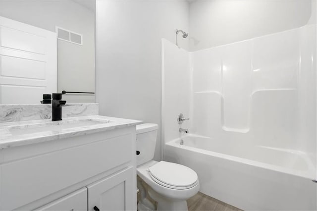 full bathroom featuring visible vents, toilet, wood finished floors, tub / shower combination, and vanity