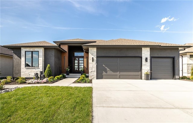 prairie-style home with a front yard and a garage