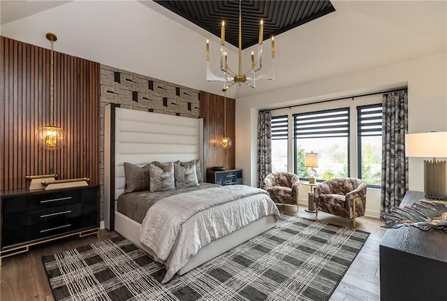 bedroom with an inviting chandelier, dark hardwood / wood-style floors, and vaulted ceiling