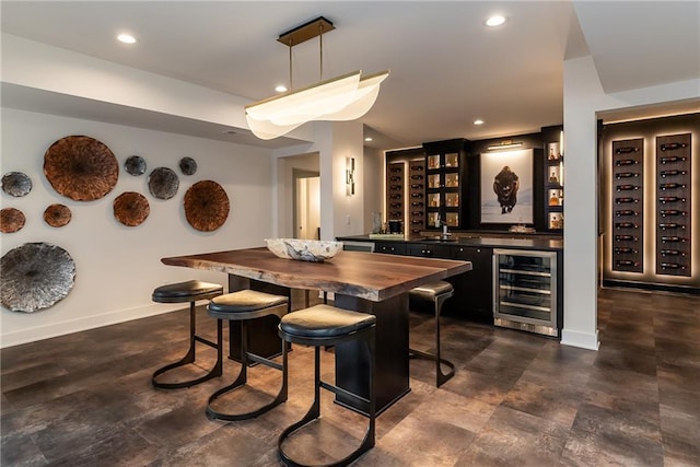 bar featuring wooden counters, pendant lighting, and beverage cooler