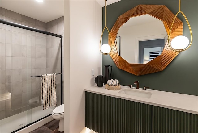 bathroom with sink, a shower with shower door, and toilet