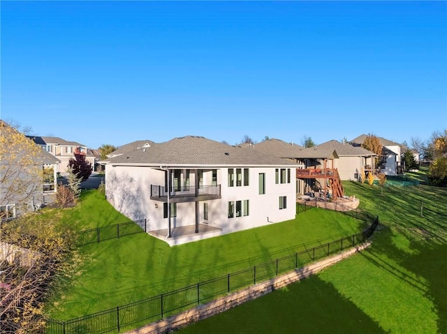 back of property with a yard and a balcony