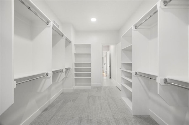 walk in closet featuring light carpet